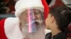 RUSSIA - An actor dressed as Santa Claus and wearing a face mask to protect against coronavirus infection speaks with a boy during the New Year celebration in a shopping mall in St.Petersburg, Russia, Saturday, Jan. 2, 2021