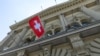 FILE PHOTO: The Swiss flag is seen on the Swiss Parliament house (Bundeshaus) in Bern